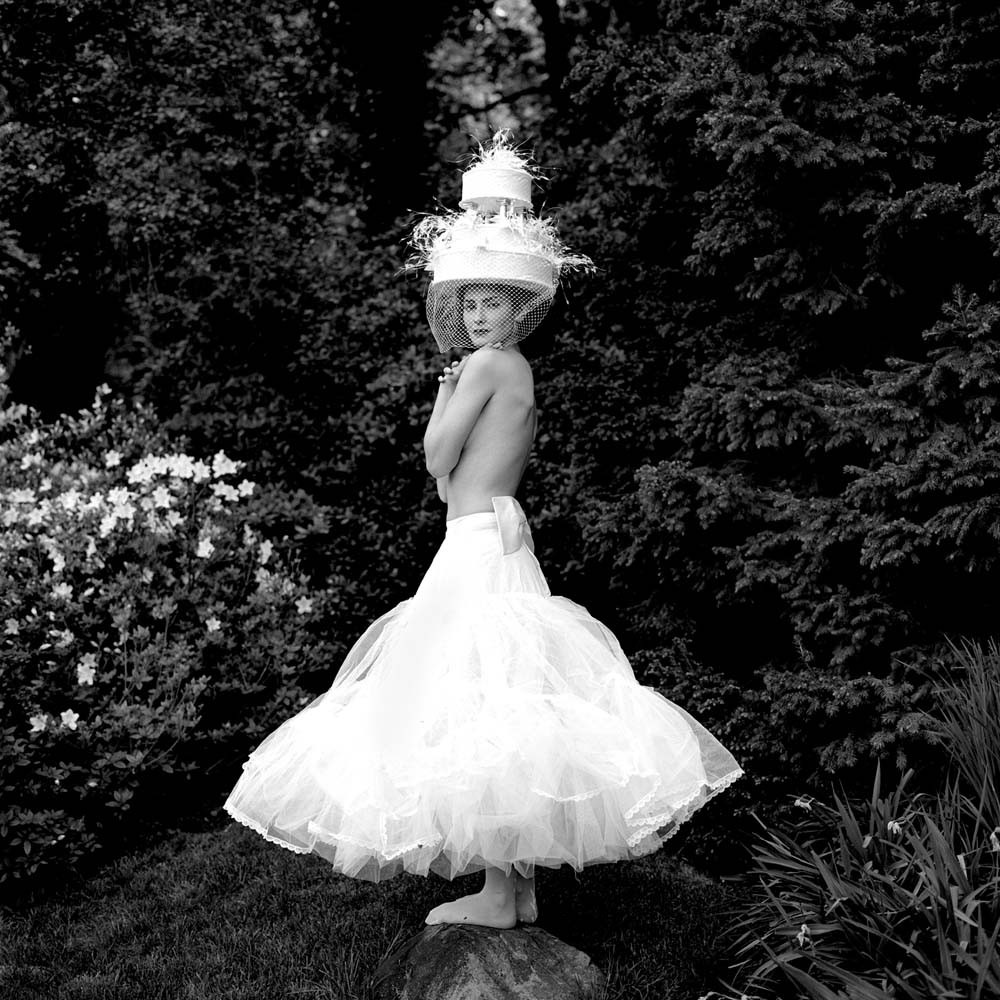 Zoe Wearing Cake Hat while Standing on Rock, Snedens Landing, New York,  2003© Rodney Smith