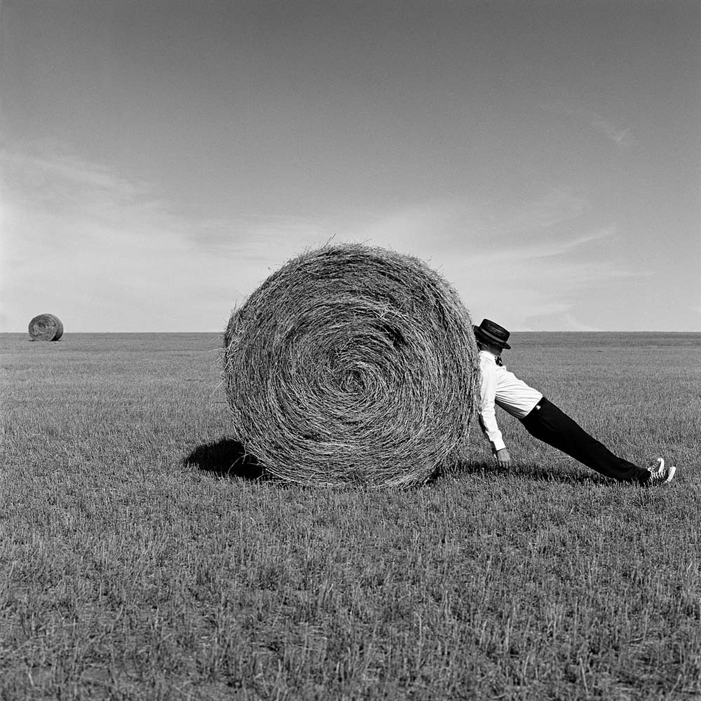 Man Leaning Against Hay Bale, Alberta, Canada, 2004© Rodney Smith